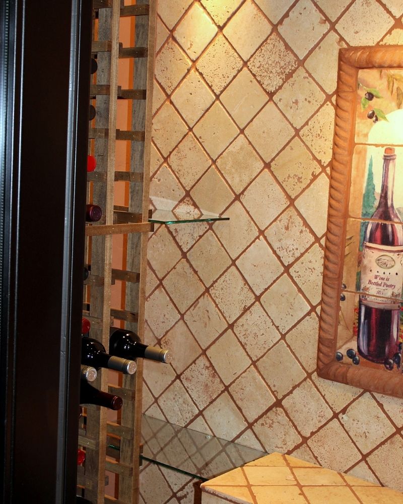 Elegant wine storage area featuring wooden racks, decorative tile walls, and a framed wine artwork. Perfect for wine lovers.