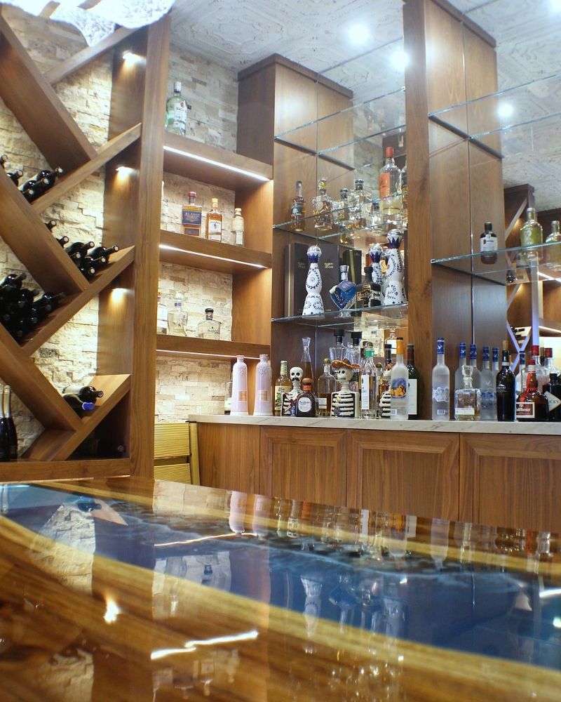 Stylish bar interior showcasing a variety of bottles and a sleek wooden countertop with ambient lighting.
