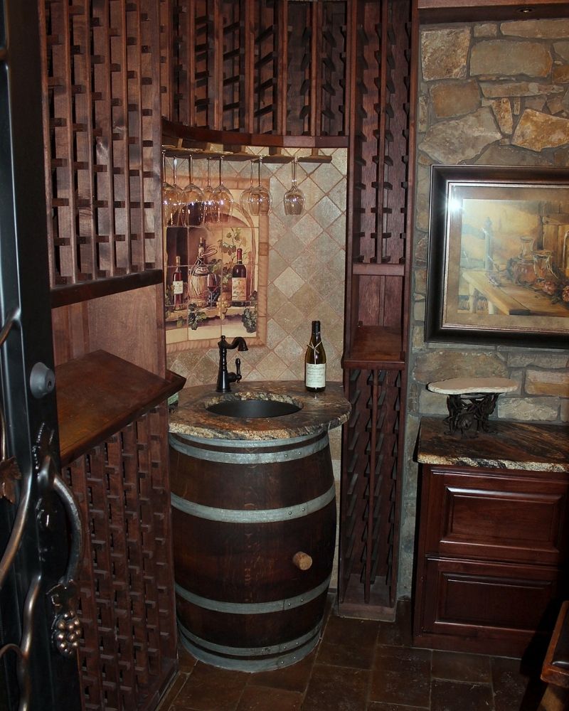 Alt text: Cozy wine nook featuring a barrel sink, wooden racks, and rustic decor for a charming ambiance.