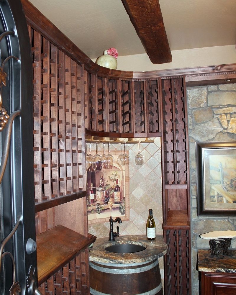 Cozy home bar featuring wooden shelves, barrel sink, wine bottles, and rustic decor, perfect for entertaining guests.