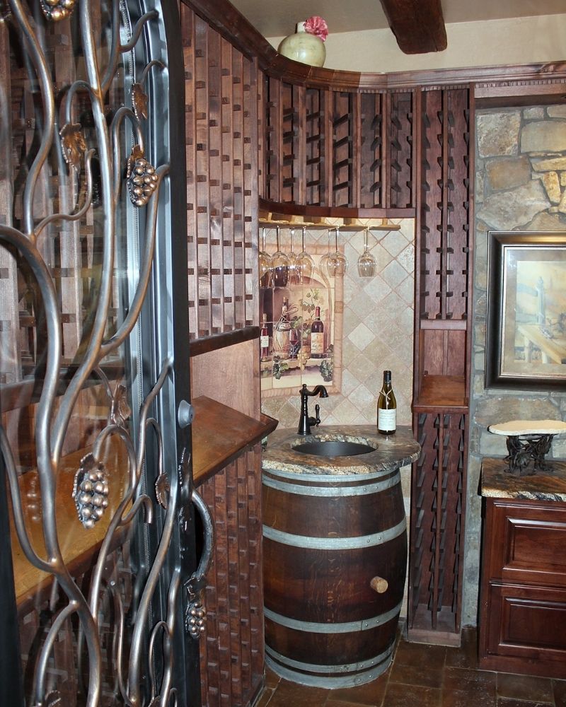 Cozy wine nook featuring rustic wood cabinetry, a barrel sink, and elegant wine storage for a charming aesthetic.