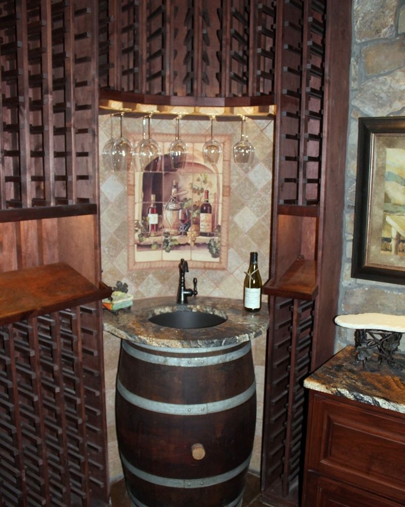Cozy wine nook featuring a barrel sink, wine glasses, and rustic decor for a charming home bar atmosphere.
