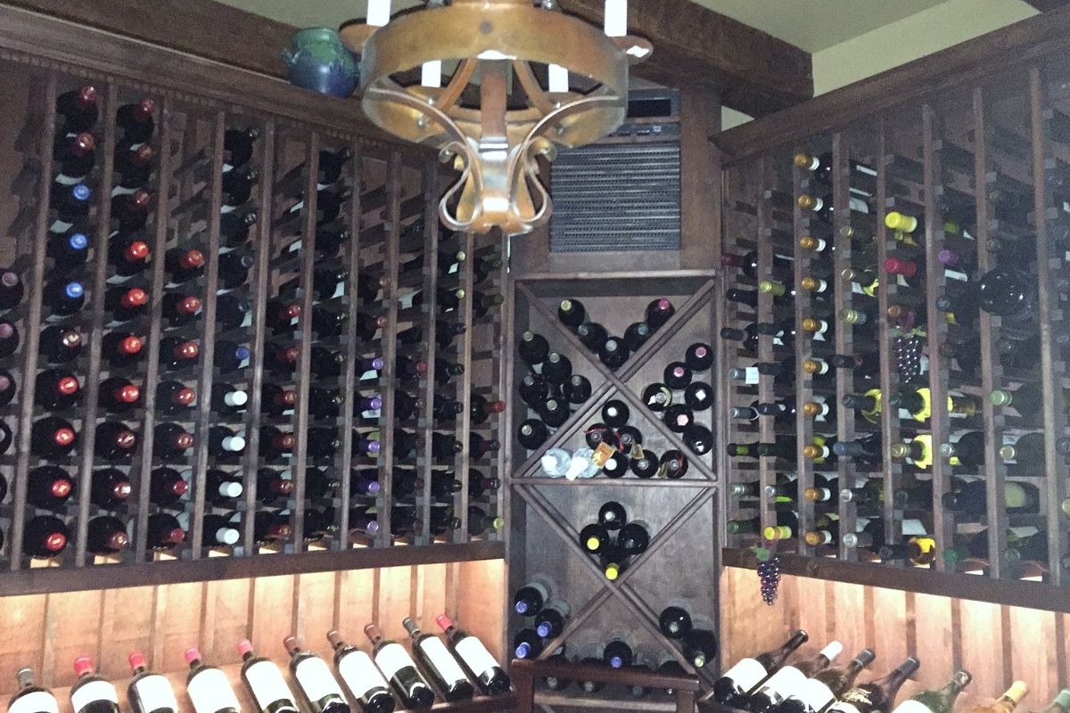 Wooden wine cellar showcasing a diverse collection of wine bottles neatly organized on shelves.