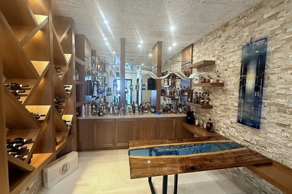Modern home bar featuring a stylish wooden design, sleek shelves, and an array of premium spirits and decor.