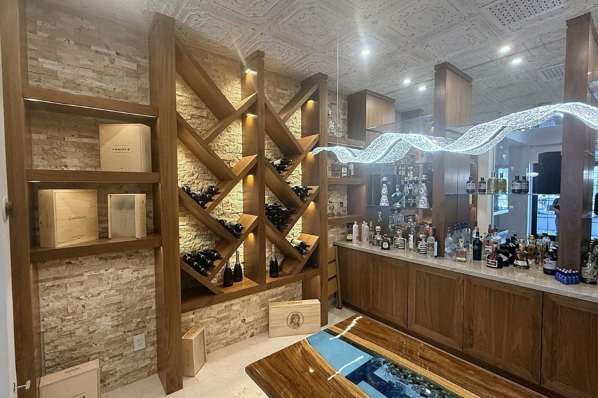 Luxury wine and spirits bar with elegant wooden shelving, LED lighting, and modern decor elements in a stylish interior.