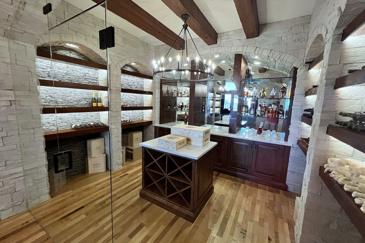 Elegant wine cellar interior featuring stone walls, wooden shelves, and a central wine storage island.