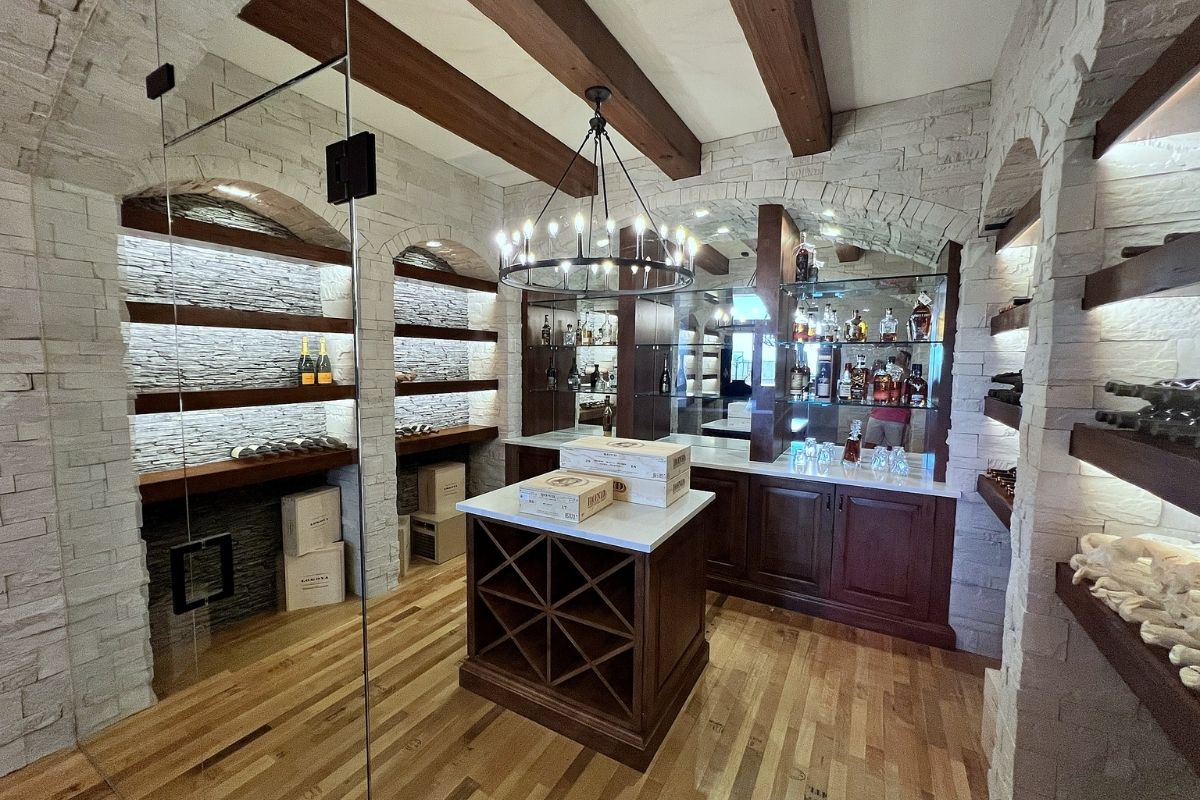 Elegant home bar with wooden shelves, wine storage, and ambient lighting, showcasing a variety of spirits and fine wines.
