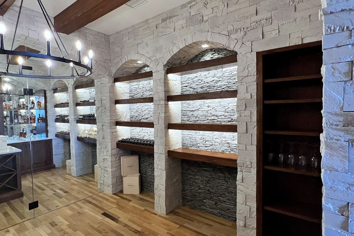 Elegant bar area featuring stone arches, illuminated shelves, and wooden accents, perfect for stylish entertaining.